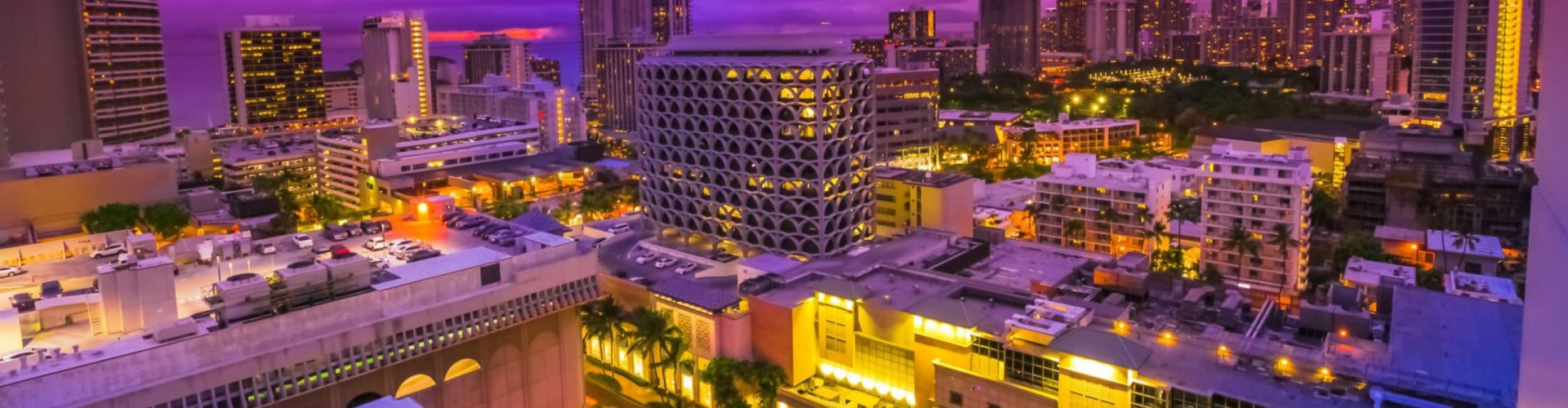 Honolulu night skyline with parked cars